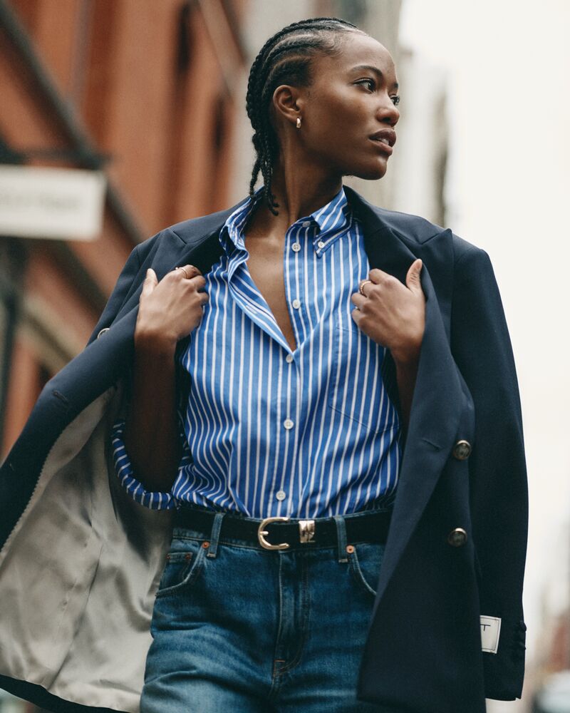 Woman wearing a blue striped shirt and dark jacket outdoors