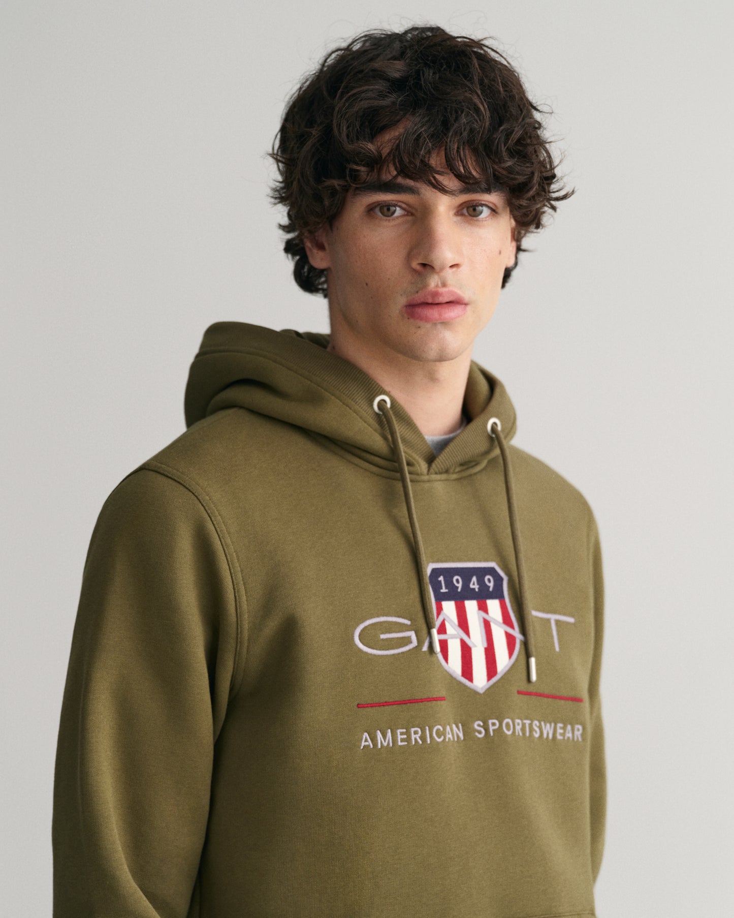 MODEL WEARING REG ARCHIVE SHIELD HOODIE