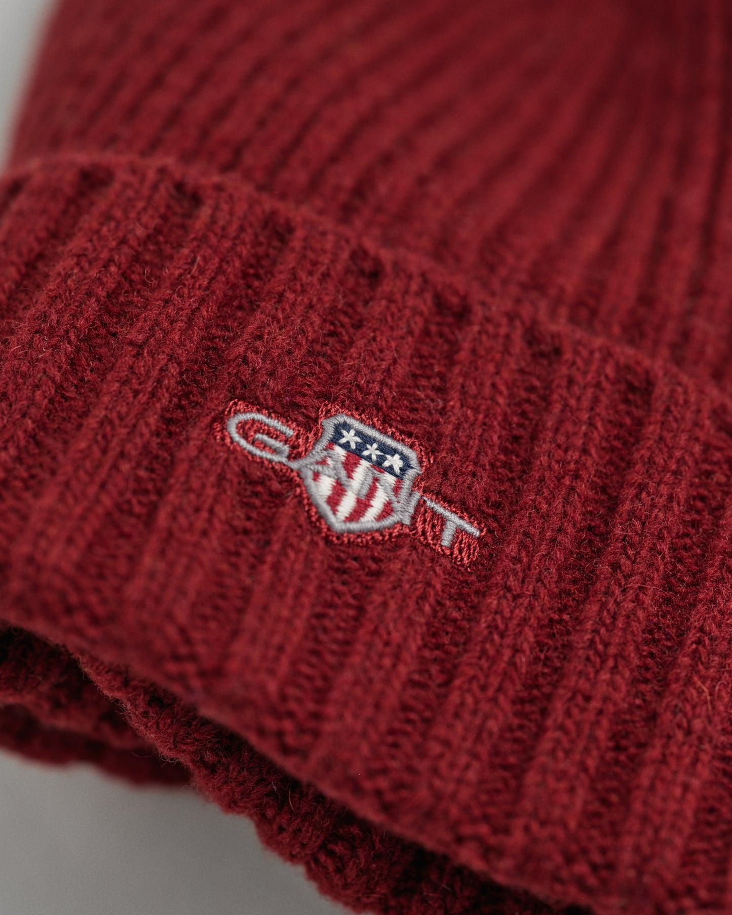 PLUMPED RED, UNISEX. SHIELD WOOL BEANIE, CLOSE-UP BY GANT AU.