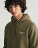 JUNIPER GREEN, REG MEDIUM ARCHIVE SHIELD HOODIE, CLOSE-UP BY GANT AU.