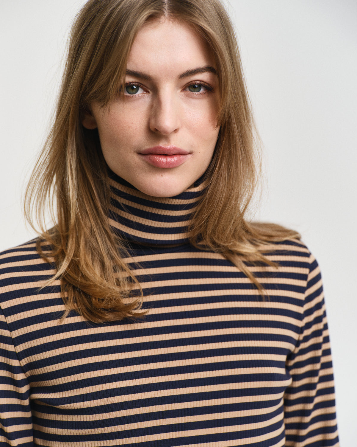MODEL WEARING SLIM STRIPED RIBBED TURTLENECK
