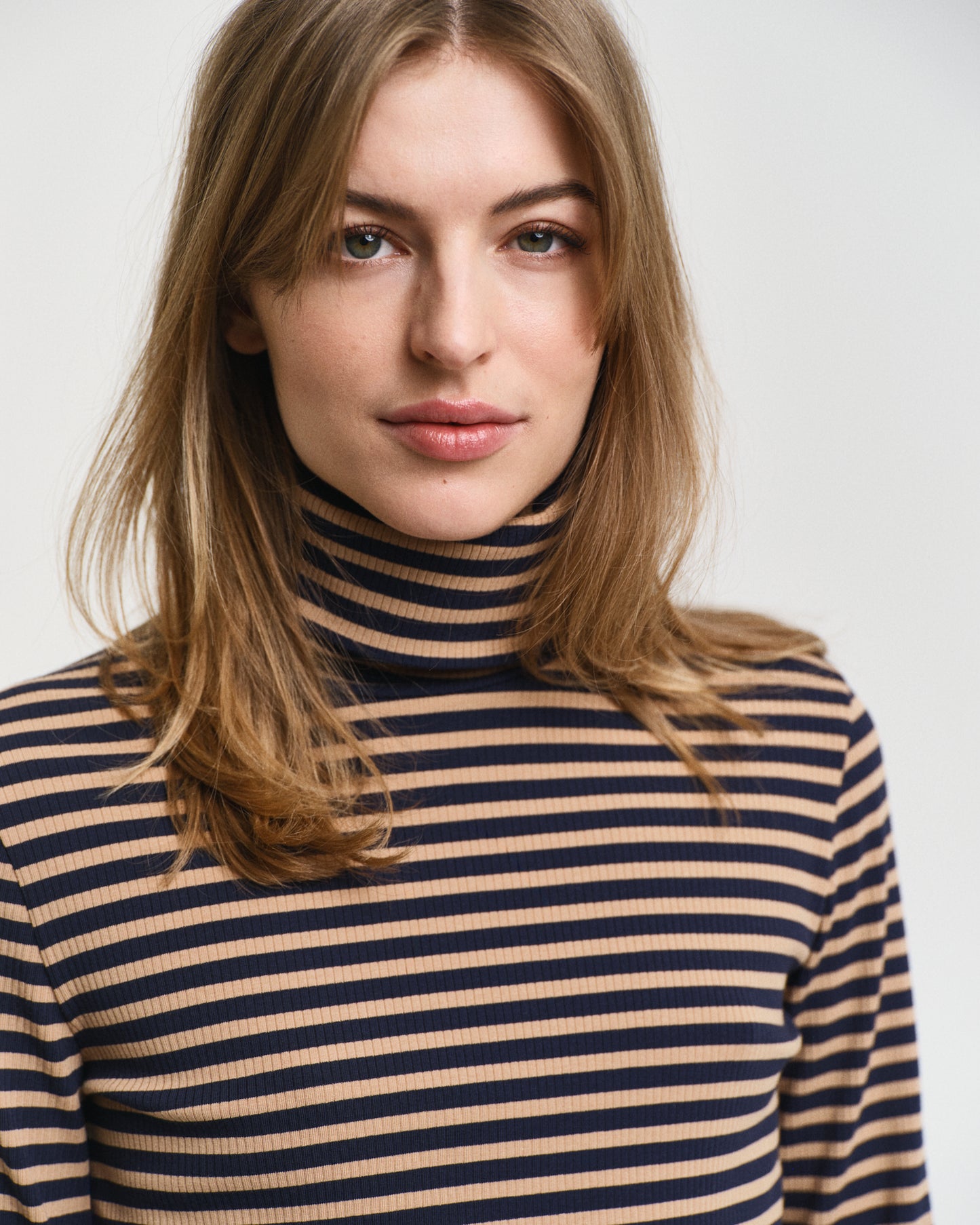 MODEL WEARING SLIM STRIPED RIBBED TURTLENECK