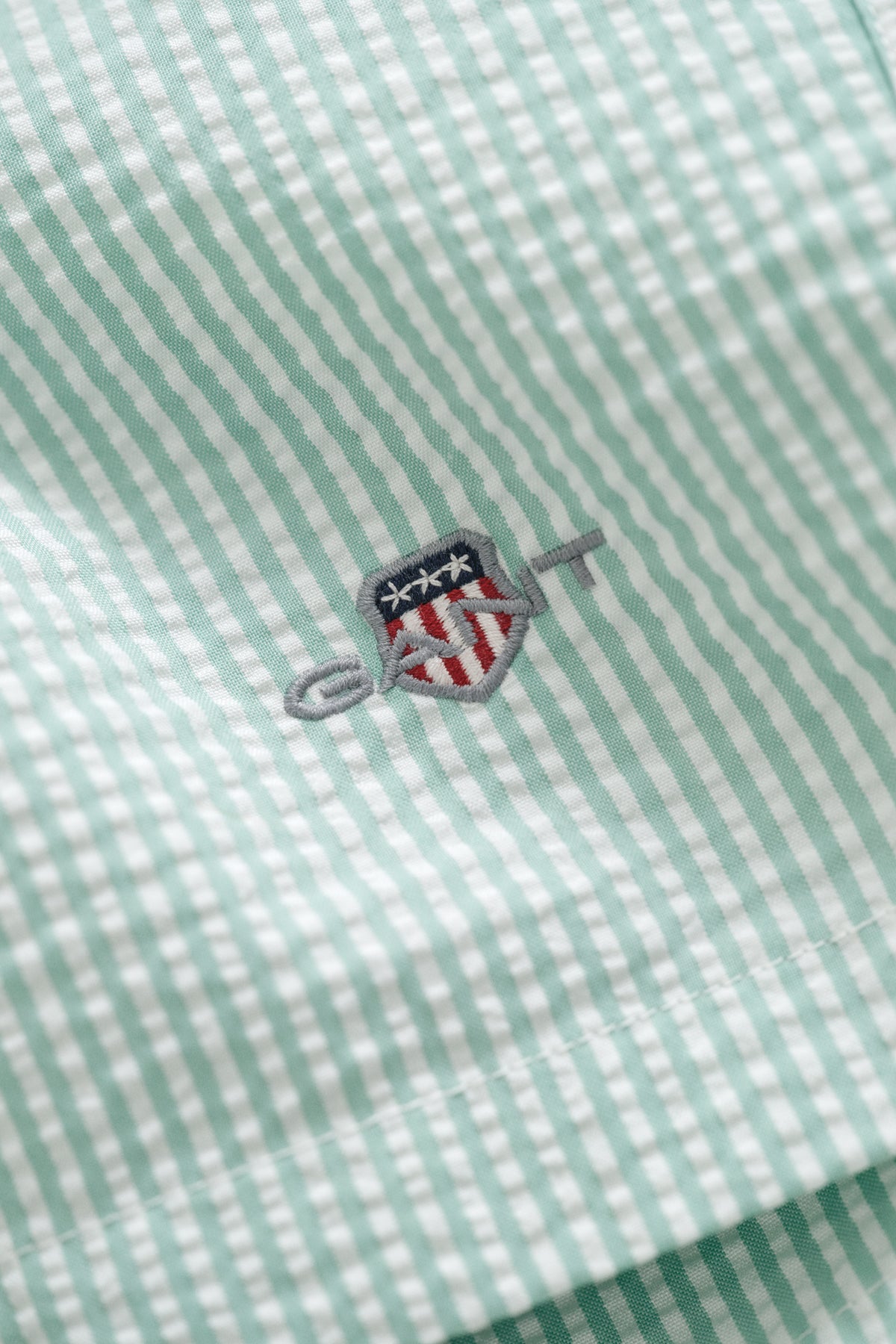 MUTED TURQUOISE, STRIPED SEERSUCKER SWIM SHORTS, FLAT-LAY BY GANT AU.