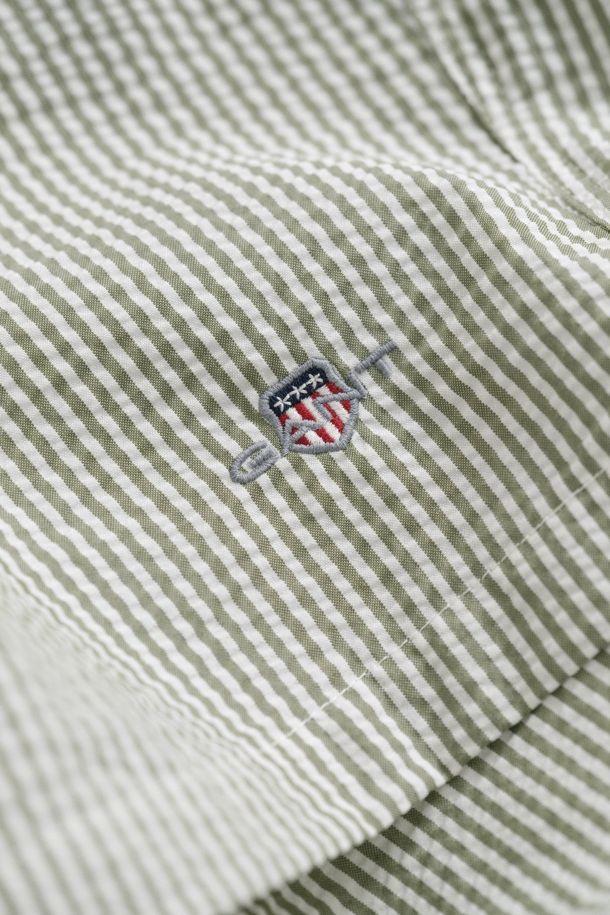 DRY HERB GREEN, STRIPED SEERSUCKER SWIM SHORTS, FLAT-LAY BY GANT AU.