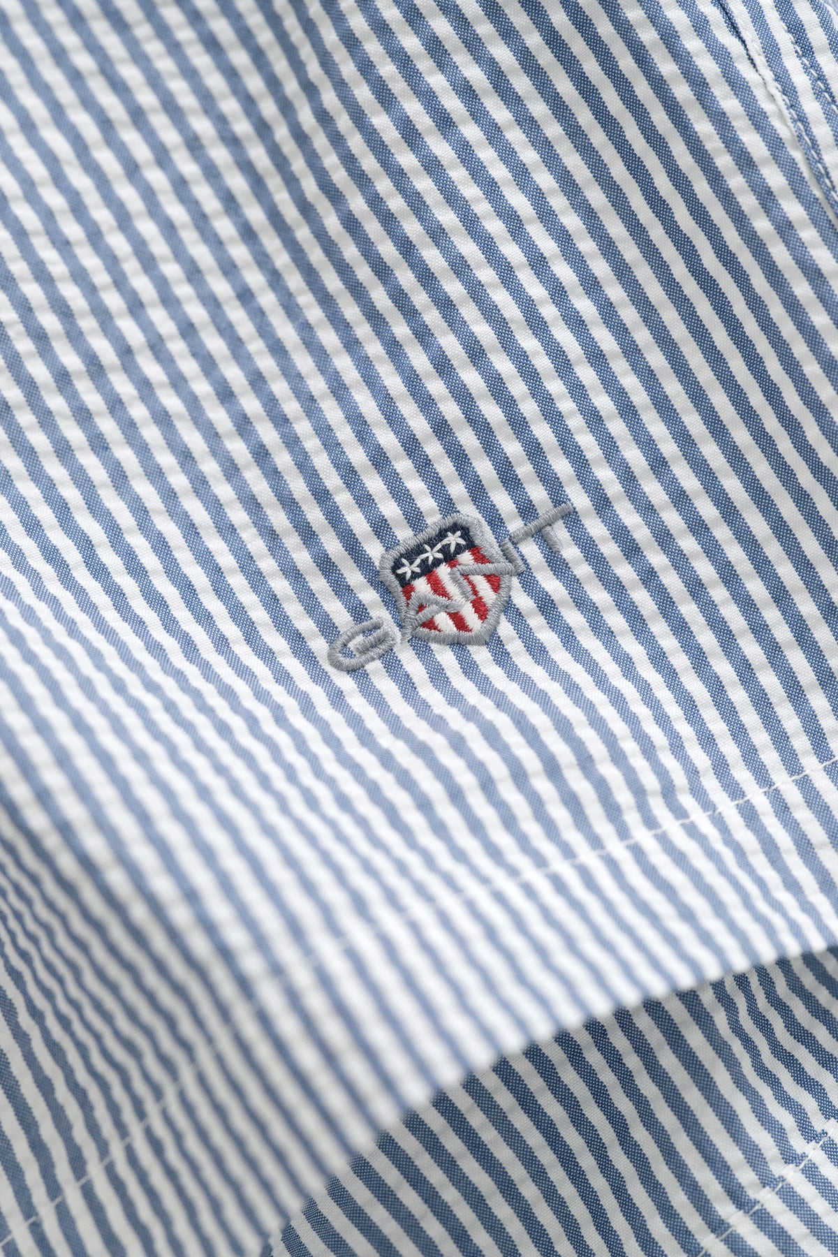 VINTAGE BLUE, STRIPED SEERSUCKER SWIM SHORTS, FLAT-LAY BY GANT AU.