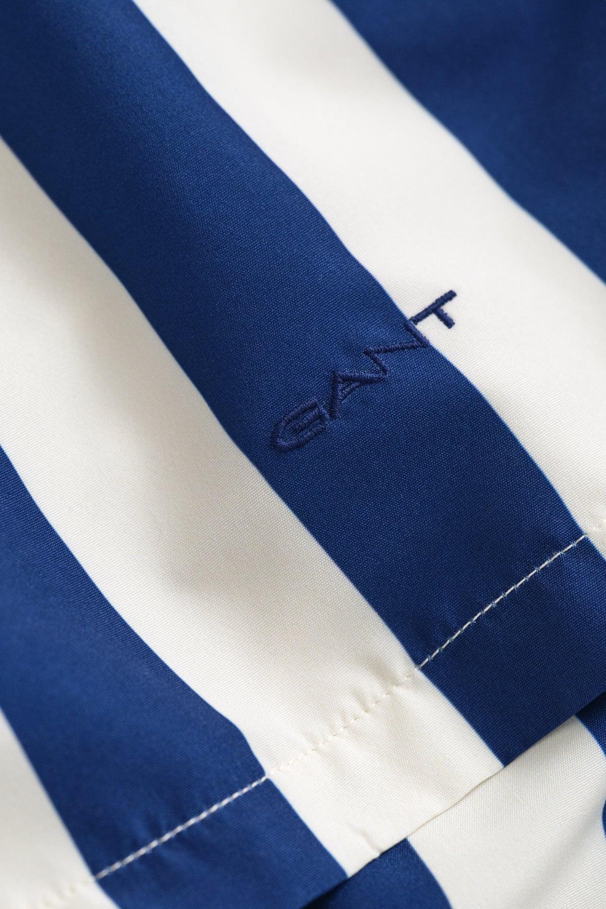 RICH NAVY, BLOCK STRIPED SWIM SHORTS, FLAT-LAY BY GANT AU.