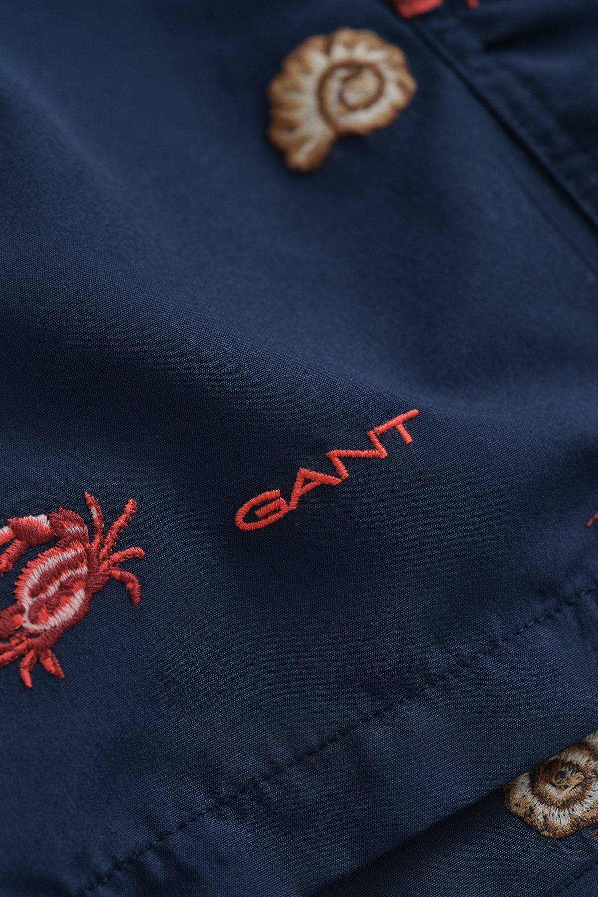 MARINE, LOBSTER EMBROIDERY SWIM SHORTS, FLAT-LAY BY GANT AU.